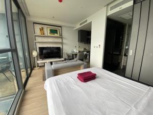 a bedroom with a white bed with a red towel on it at Stunning Sea View Condo -Next To Beach in Pattaya South