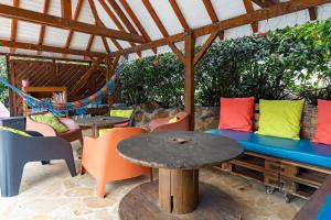 a patio with tables and chairs and a bench at Gites villa bagatelle piscine et Plage à 900m in Sainte-Rose