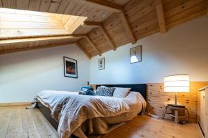 a bedroom with a bed in a room with wooden ceilings at Chalet Nanouk - exposé plein sud in La Salle-les-Alpes