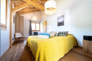 a bedroom with a bed with a yellow blanket at Chalet Nanouk - exposé plein sud in La Salle-les-Alpes