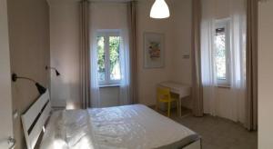 ein Schlafzimmer mit Bett, Schreibtisch und zwei Fenstern in der Unterkunft Bambù Affittacamere & Residence in Teramo