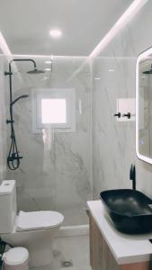 a bathroom with a black sink and a toilet at Ina's apartments in Lefkimmi