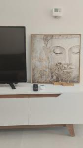 a television sitting on top of a white cabinet at Ina's apartments in Lefkimmi