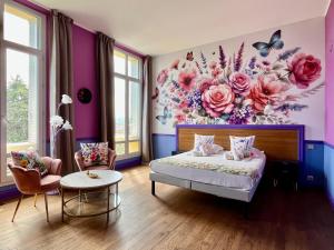 a bedroom with a bed with a flower mural on the wall at Hôtel Windsor in Cannes
