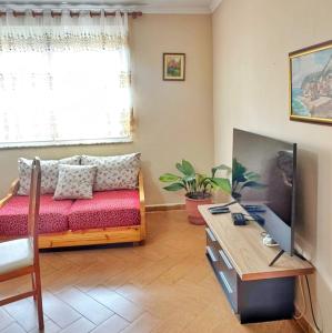 a living room with a couch and a tv at N'Baz Apartment Lezhë in Lezhë