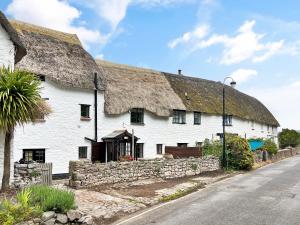 a large white building with a thatched roof at Bobs Cottage Porlock Weir in Porlock
