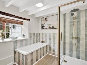 a bathroom with a bath tub and a shower at Bobs Cottage Porlock Weir in Porlock +18 photos