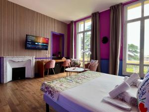 a hotel room with a bed and a tv on the wall at Hôtel Windsor in Cannes