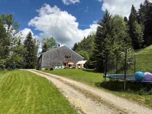 a dirt road next to a house with a table at Dharma Farm Retreat in Mijoux