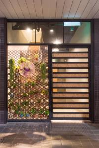 Hostel Jiizu في تايبيه: واجهة متجر عليها نافذة عليها نباتات
