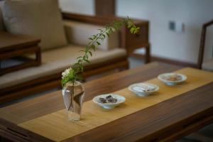 a vase with a plant in it on a coffee table at Qingcheng Mountain Wujing Mountain Residence in Dujiangyan