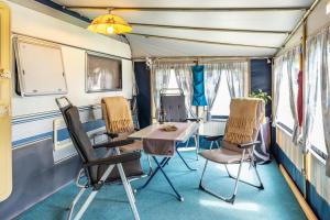 a dining room in a train car with chairs and a table at La Pura Vida - Glamping in Brandenburg an der Havel