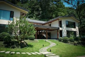 a house with a walkway in front of a yard at Qingcheng Mountain Wujing Mountain Residence in Dujiangyan