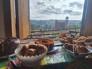 a table topped with plates of pastries and a window at Pousada Dona Terezinha in Formiga