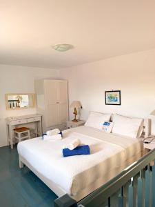 a bedroom with a large white bed and a desk at White Blue Houses & Apartments Paros in Parikia