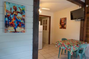 a dining room with a table and a tv at Gites villa bagatelle piscine et Plage à 900m in Sainte-Rose