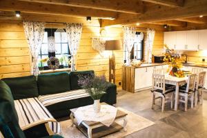 a living room with a green couch and a kitchen at Mysia Nora in Smerek
