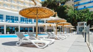 a row of chairs and umbrellas next to a pool at Bahia Principe Escape Coral Playa Adults Only in Magaluf +35 photos