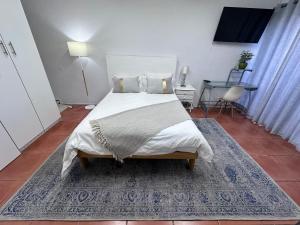 a bedroom with a large bed with a blue rug at Protea Hoogte Flatlet in Brackenfell