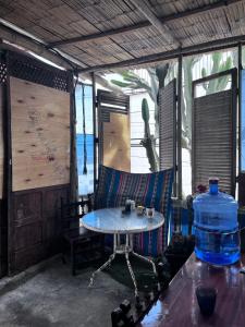 a table and chairs in a room with a water bottle at Huanchaco Surf Camp in Huanchaco