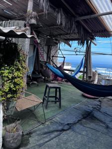 a hammock in a house with a table and a chair at Huanchaco Surf Camp in Huanchaco