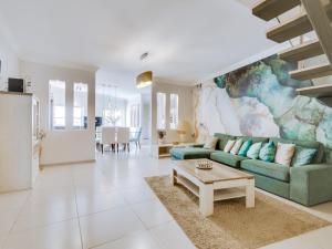 a living room with a green couch and a table at Villa Monica with Private Pool and Jacuzzi in Quarteira