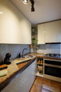 a kitchen with white cabinets and a sink at ZAZA Apartament - central area, with balcony in Târgu Jiu