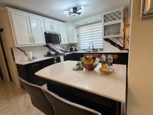 a kitchen with white cabinets and a counter with drinks on it at Elysium Noire in Spanish Town