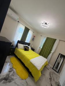 a bedroom with a yellow bed with a yellow blanket at Elysium Noire in Spanish Town
