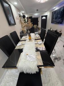 a long dining room table with a white rug on it at Elysium Noire in Spanish Town