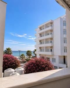 a view of a building and the beach from a balcony at Flors Apartments in Durrës