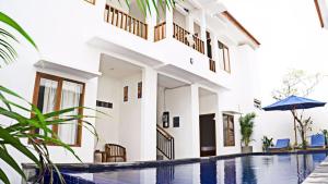 a house with a swimming pool in front of a building at The Kayuri in Canggu