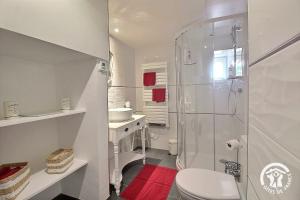a white bathroom with a shower and a toilet at Le parfum des fleurs in Plussulien +39 photos