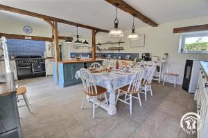 a dining room with a table and chairs in a kitchen at Le parfum des fleurs in Plussulien