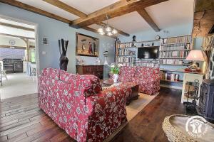 a living room with two red couches and a table at Le parfum des fleurs in Plussulien