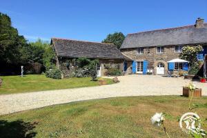 a large stone house with a gravel driveway at Le parfum des fleurs in Plussulien