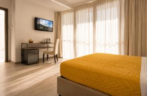 a hotel room with a bed and a desk and a television at Il Rifugio Dei Templari in Lecce