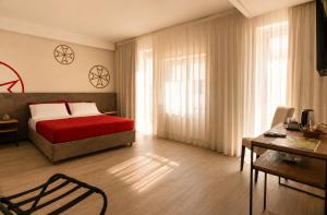 a bedroom with a bed and a desk and a chair at Il Rifugio Dei Templari in Lecce