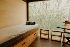 a room with a bed and a large window at Glamping Všímarský potok in Malšín