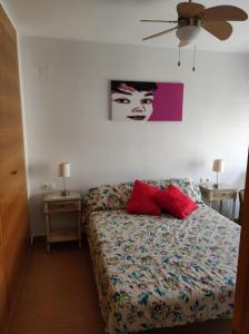 a bedroom with a bed with two red pillows on it at Apartamento rodeado de mar y montañ in El Verger