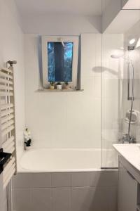 a white bathroom with a shower and a window at ZAZA Apartament - central area, with balcony in Târgu Jiu +31 photos
