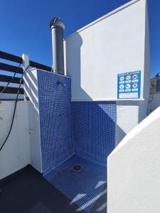 a blue tile shower on the side of a building at Apartamento rodeado de mar y montañ in El Verger +2 photos