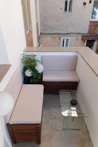 a balcony with two benches and a glass table at ZAZA Apartament - central area, with balcony in Târgu Jiu