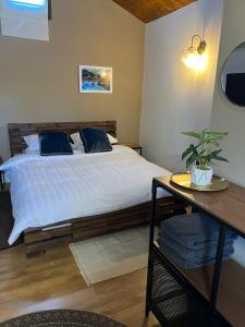a bedroom with a bed and a table with a potted plant at פרא בקתות אירוח - מתחם נופש כפרי עם בריכה פרטית in Nir Yafe