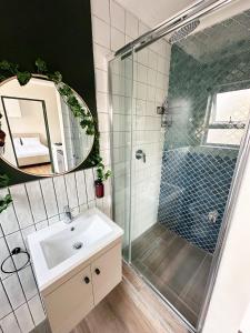 a bathroom with a shower and a sink and a mirror at Silwood Heights Flatlet in Eerste River in Faure +14 photos