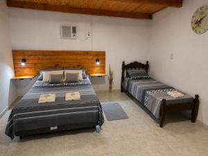 a bedroom with two beds and a clock on the wall at Alojamientos Adele II in San Miguel