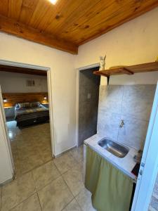 a kitchen with a sink and a living room at Alojamientos Adele II in San Miguel