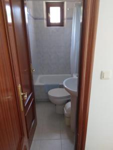 a bathroom with a toilet and a tub and a sink at Posada San Miguel in RIonansa