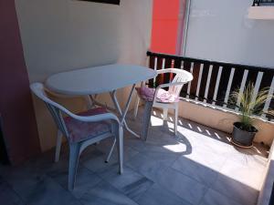 a table and two chairs sitting on a balcony at Haras rooms in Nikiana