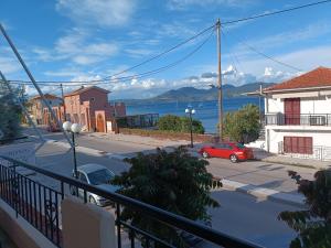 a red car parked on a street next to the water at Haras rooms in Nikiana
